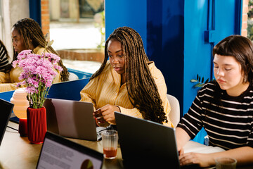 Black female entrepreneur working on a laptop during creative meeting