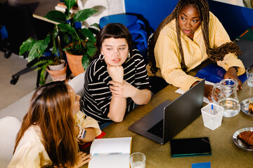 Female entrepreneurs chatting cheerfully during a work meeting