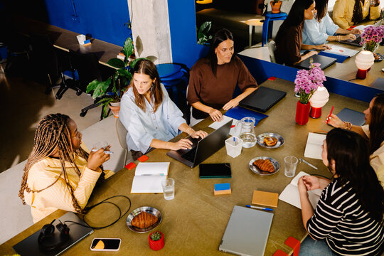 Coworkers gathered around a boardroom table in a women-led company