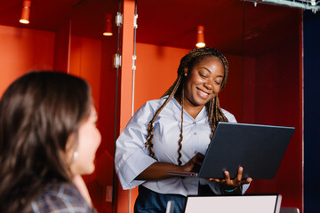 Diverse woman guiding a team discussion in a tech company 