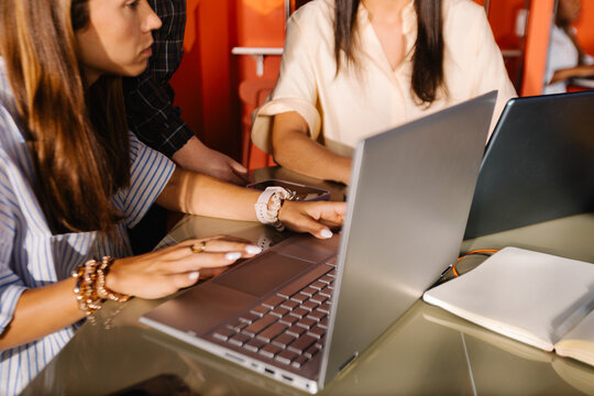 A creative female work team using laptops to develop a project.