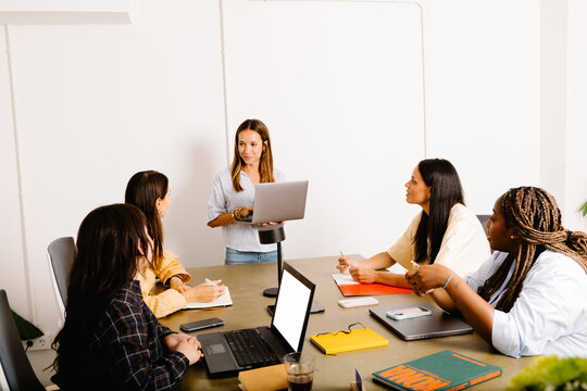 Female executive from a digital startup gives a talk to a team