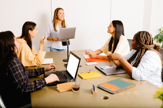 A woman entrepreneur presenting to a group of female creatives