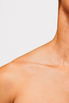 Abstract close-up of male shoulder and collarbone on white background