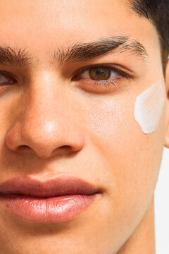 Extreme close-up of young man&acirc;s face with skincare cream