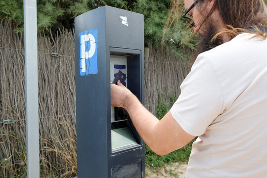 Man Paying at Parking Machine