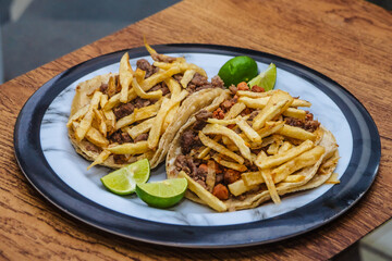 Mexican beef jerky tacos with fries on top and lemons on the side, tacos from Mexico City and Mexico State, edomex