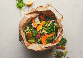 brown bag with various vegetable peelings and scraps, showing the importance of composting in reducing food waste at home