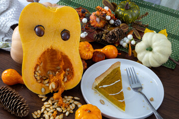Pumpkin tart with a spider web design, surrounded by autumn decorations of pumpkins, leaves, and pinecones