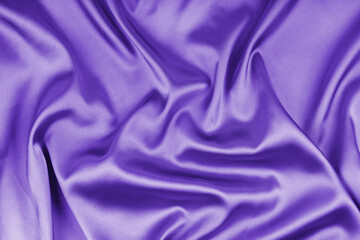 Crumpled, wrinkled purple colored glossy silk satin texture. Shiny smooth fabric with soft folds, cloth with wave drapery. Elegant and rich background, wallpaper, backdrop. Flat lay, top view