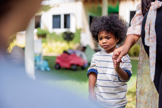 Child holds hand, looking uncertain