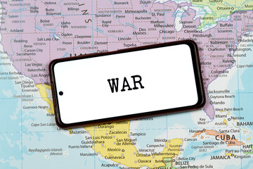 an a smart phone with a black war word over a north american political map