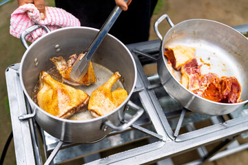 Chef cooking duck legs outdoors for restaurant