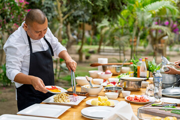 Chef preparing fresh ingredients outdoors for a dish