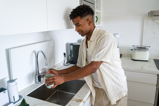 man filling cup of water