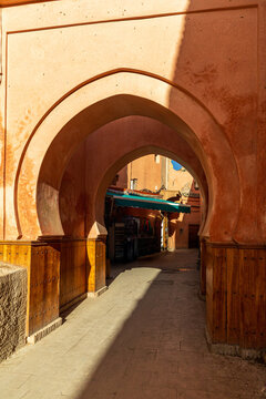 Sunlit Moroccan archway in narrow medina alley
