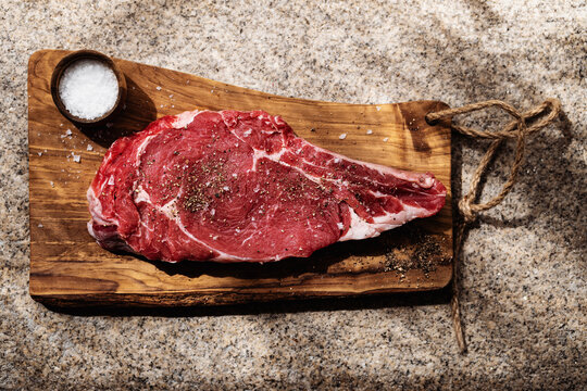 Freshly Cut Ribeye Steak on Wooden Board Ready for Cooking