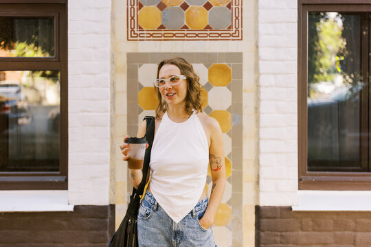Woman in Casual Attire Stands Outside a Colorful Tile Wall