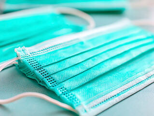  close-up shot shows folded, light blue, medical face masks with white elastic ear loops