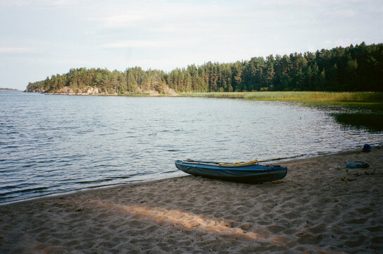 Kayak on a Sandy Beach by the Calm Lake Surrounded by Trees