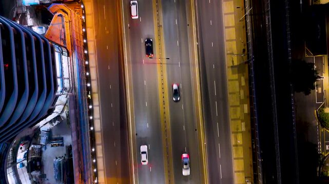 Aerial night view of London highway with traffic, skyscrapers and city lights, capturing urban movement, modern development and evening skyline.
