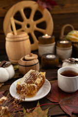 Fototapeta premium lose-up of a honeycomb on a white plate surrounded by a wooden barrel and a cup. a warm and rustic atmosphere. Bee honey.