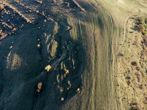 Hill in grassland at sunset