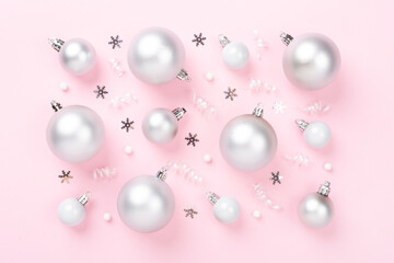 Grey Christmas balls with decor on color background, top view