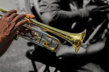 Obraz premium A talented musician passionately plays a trumpet during a lively outdoor event. The environment is filled with energy, highlighting the joy of music in the city scene.