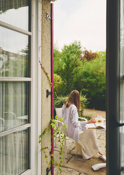 Woman Enjoying Breakfast in Garden Terrace  in France