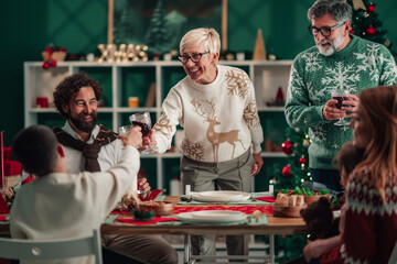 Family toasting with red wine, celebrating christmas dinner at home