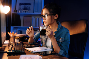 Creating young beautiful Asian creative woman thinking of sales target report on business market graph folder paperwork report, looking out of indoor with holding pen at neon at night time. Stratagem.