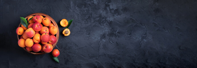 Ripe apricots on black background. Top view, copy space. Fruit banner. Healthy vegetarian food,...