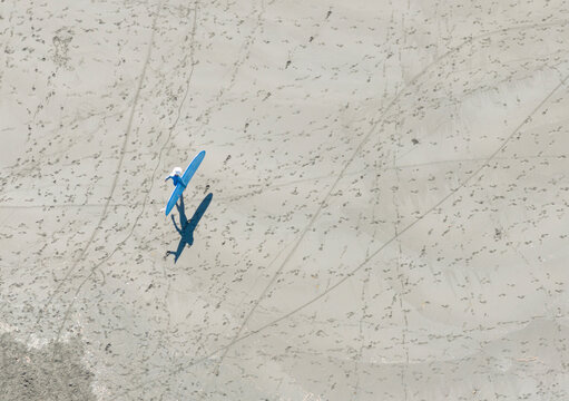 Aerial View Surfer Walking on Beach with White Surfboard