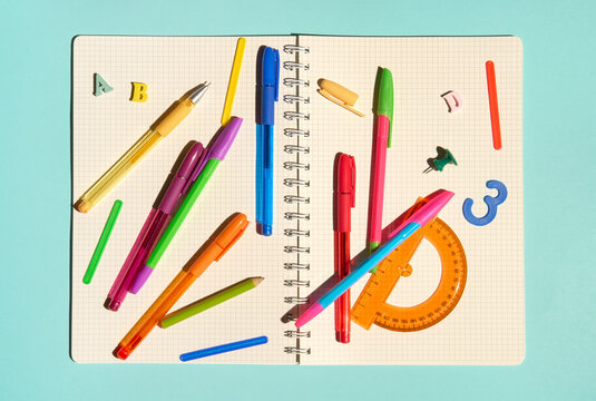 Colorful Flat Lay with Stationery Items on Blank White Pages with Grid