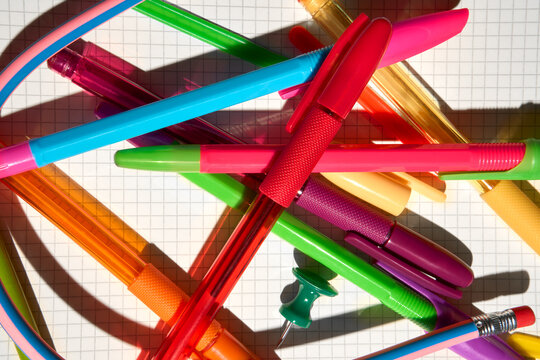 Variety of Colorful Pens, Pencils and Stationery on Graph Paper.