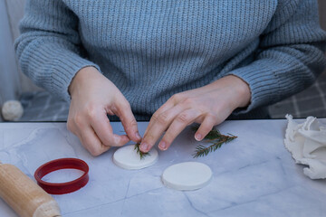 Creator is using white air dry clay for making decor to Christmas tree holiday. Creating hobby recreation activity that involves fingers. DIY crafting Modern art 