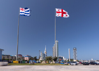 Two flags of Georgia and Adjara flying in front of Batumi cityscape in Batumi Georgia