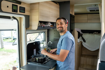 Tourist cooking in camper van kitchen