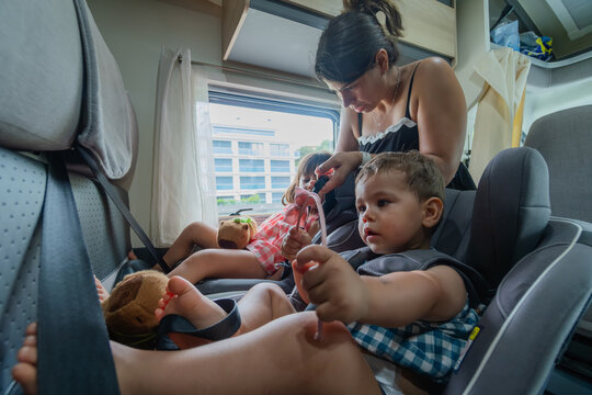 Mother fastening kids in car