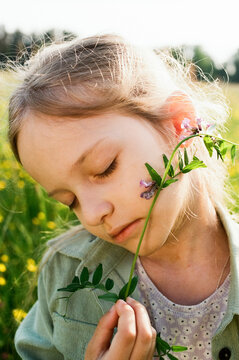 Peaceful Girl with Closed Eyes Holding Wildflower