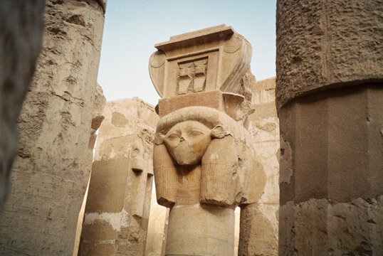 Ancient Egyptian temple pillar with goddess carving

