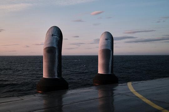 Dramatic Ocean View With Metallic Structures at Sunset on a Cloudy Day