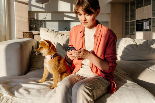 Woman checking GPS tracker for dog with smartphone