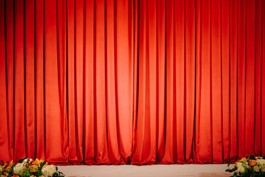 Red stage curtains covering performance venue background