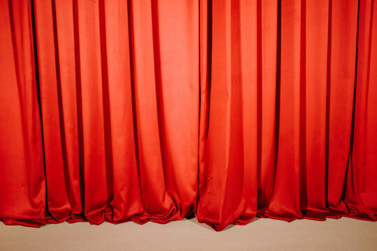 Red stage curtain covering floor in theater