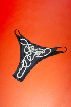 Black underwear panties with shiny pearl jewellery necklace 