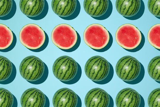 Watermelons arranged in a symmetrical pattern on a blue background