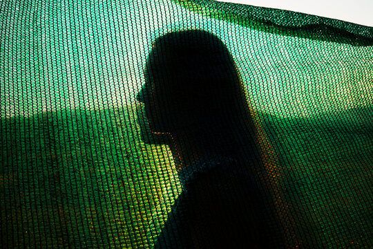 Person Silhouetted Against Green Backdrop at Sunset