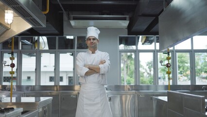 Portrait male chef standing with his arms crossed in the kitchen